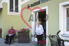 Ein alter Mann Senior im Rollstuhl und eine alte Frau Seniorin kommen aus einer AWO Tagesbetreuung