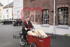  Mann auf einem mit Paketen beladenem Lastenrad