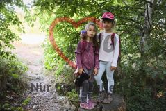 zwei Mädchen, eins davon mit AWO-Käppi, im Wald